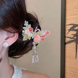 Close-up detail of vintage butterfly embroidery hair clip with metallic tassels on hair