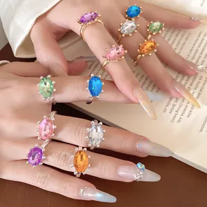 Detailansicht von mehreren bunten ovalen Strass-Ringen an elegant gepflegten Händen