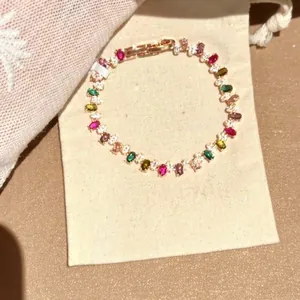 Nahaufnahme eines eleganten vergoldeten Armbands mit bunten Steinen auf einem Schmuckbeutel