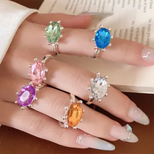 Makroansicht einer Sammlung farbenfroher offener Ringe mit ovalen Edelsteinen an Fingern