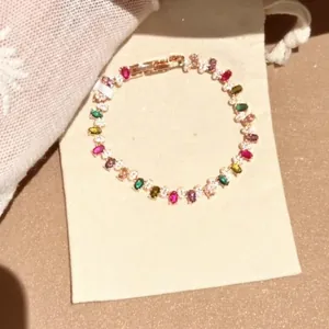 Detailansicht eines bunten Regenbogen-Edelsteinarmbands auf einem Beutel