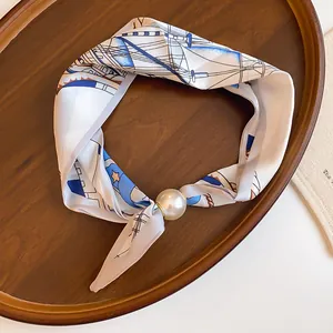 Eleganter Seidenschal-Halskette mit Perlenanhänger auf einem Holztablett präsentiert