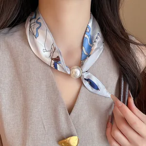Detailansicht einer eleganten Seidenschal-Halskette mit einem großen Perlenanhänger-Detail.