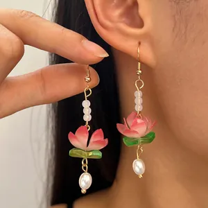 Detail of handcrafted lotus flower earrings with elegant pearl drops in New Chinese style.
