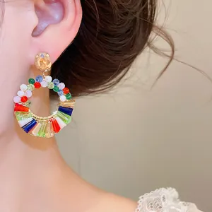 Nahaufnahme von luxuriösen Regenbogen Kristall Creolen im Bohème-Stil am Ohr des Models