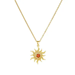 Detailed view of gold-plated sunburst pendant with vibrant orange center stone