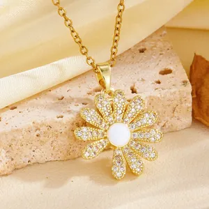 Macro view of an elegant gold flower pendant necklace with sparkling clear stone settings