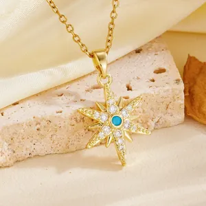 Detailed view of a gold-plated eight-pointed star pendant with turquoise and clear stones