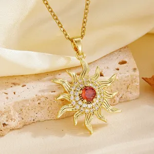 Detailed macro shot of a gold sunburst pendant necklace featuring a central red stone