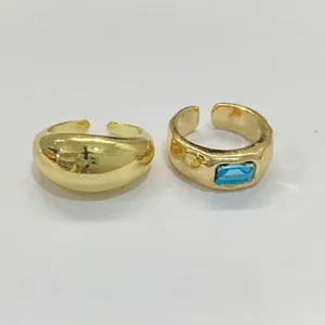 Detail of gold geometric toe rings featuring a blue rectangular gemstone and smooth dome design