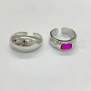 Detail view of two silver adjustable toe rings, one with a pink rectangular stone