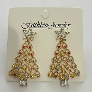 Close-up of golden Christmas tree earrings with colorful rhinestones on a display card