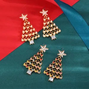 Detailed view of two pairs of gold-plated Christmas tree earrings with colorful rhinestones