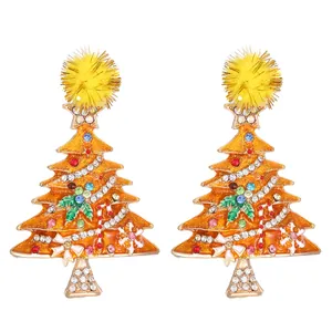 Close-up detail of vibrant Christmas tree earrings with sparkling rhinestones and a yellow pom-pom