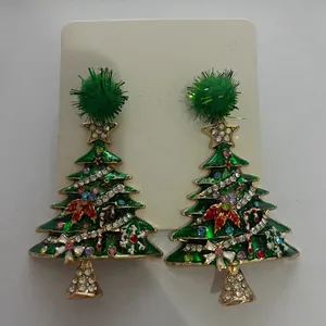 Detailed view of festive Christmas tree earrings with colorful rhinestones and green pom-poms