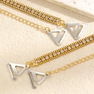 Detailed view of elegant golden bra straps featuring sparkling rhinestones and silver hooks.
