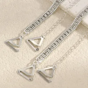 Close-up detail of fashionable shiny silver rhinestone bra straps with metal triangle hooks