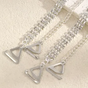 Detail view of sparkling rhinestone bra straps with silver metal triangle hooks