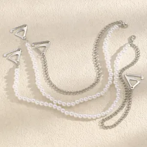 Detail of decorative bra straps featuring white pearls and silver-toned chains