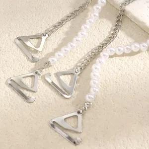 Detail showing elegant bra straps with white pearls and silver-colored chain and hooks