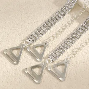 Close-up of triple-row rhinestone decorative bra straps with silver triangle hooks