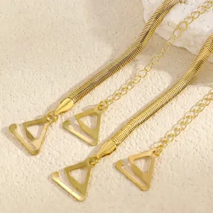 Detail showing the golden snake chain texture and triangle hook of the metal bra strap.