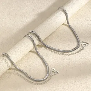 Detailed macro view of silver snake chain bra straps with decorative triangle metal clips