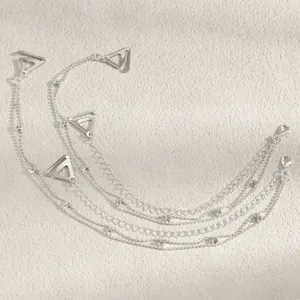 Close-up detail of silver decorative bra straps with crystals and triangular buckles