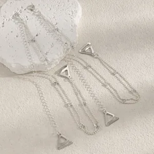 Close-up of decorative silver bra straps featuring crystal accents and triangle hooks