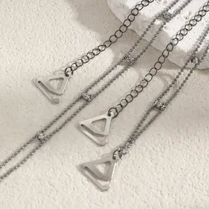 Close-up of decorative silver metal bra straps with crystal accents and triangular hooks.