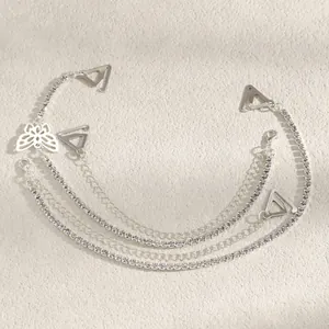 Macro view of silver rhinestone bra strap body chain featuring decorative butterfly charm