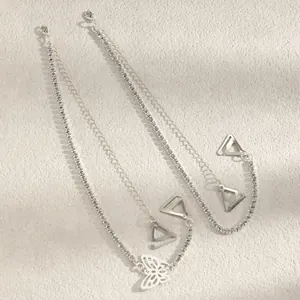 Detailed view of silver rhinestone bra straps with white butterfly charm and hooks