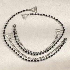 Close-up detail of silver-tone chain bra straps with elegant black square rhinestones