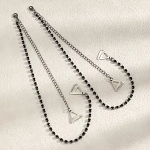 Detailed view of fashionable black rhinestone bra straps featuring elegant metal hooks