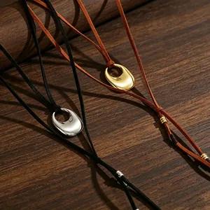 Detailansicht der Vintage-Halsketten mit Stierkopf-Anhänger an brauner und schwarzer Kordel.