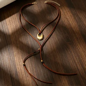 Detailansicht einer Vintage-Boho-Halskette mit brauner Kordel und goldenem Halbmond-Anhänger