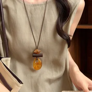 Vintage etnische ketting met barnsteen hanger en bruin leren koord op model