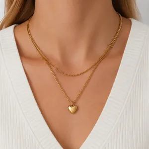 Dettaglio della collana a due strati placcata in oro con un ciondolo a cuore liscio
