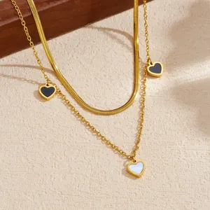 Primo piano dettagliato di una collana a doppio strato placcata in oro con ciondoli a cuore