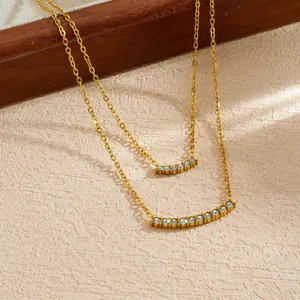 Primo piano di collana placcata oro a due strati con pendenti ad arco con pietre