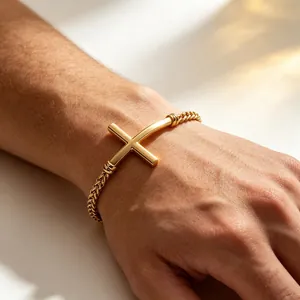 Detailansicht eines goldfarbenen Herren-Edelstahl-Kreuzarmbands an einem Handgelenk