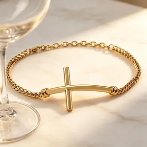 Detail view of a gold-toned stainless steel bracelet featuring a curved cross centerpiece.