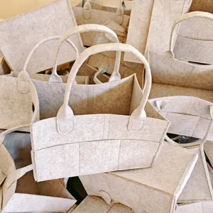 Detailed view of multiple large capacity grey felt diaper bags for nursery storage