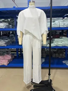 Elegantes weißes zweiteiliges Set mit Rollkragen-Top und Hose mit vorderem Schlitz auf Mannequin