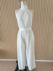 Elegant white halter neck backless wide-leg jumpsuit for women on a mannequin display