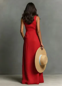 Back view of a vibrant red sleeveless floor-length summer maxi dress held with a straw hat