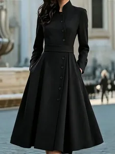Elegant black long-sleeved dress with front buttons and pockets in a classic A-line silhouette.