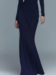 Dettaglio dell'abito da sera blu scuro con eleganti drappeggi in vita.