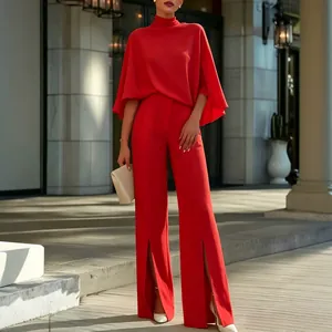 Elegantes rotes Set mit Stehkragen-Cape und High-Waist-Hose mit Beinschlitzen.