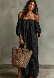 Full view of elegant off-shoulder striped maxi dress with puff sleeves and straw bag